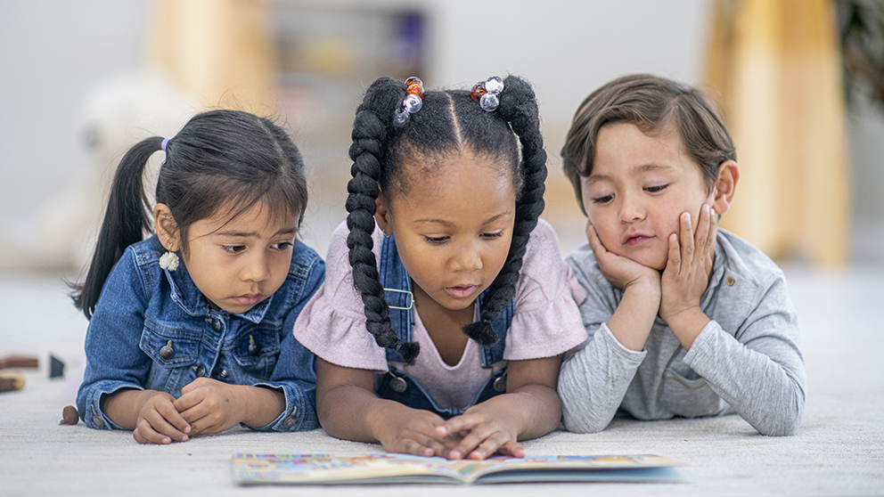 Kids reading a book.